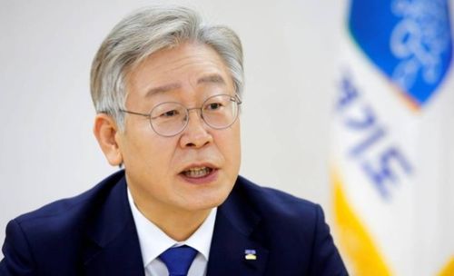 李在明手持麦克风面对媒体采访