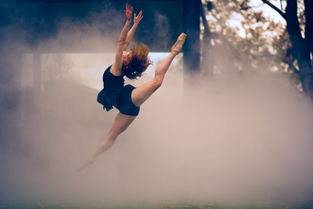 摄影师专注拍摄舞者动作，背景为城市夜景