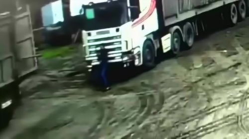 一名男子在卡车旁挥舞手臂并打开手机闪光灯