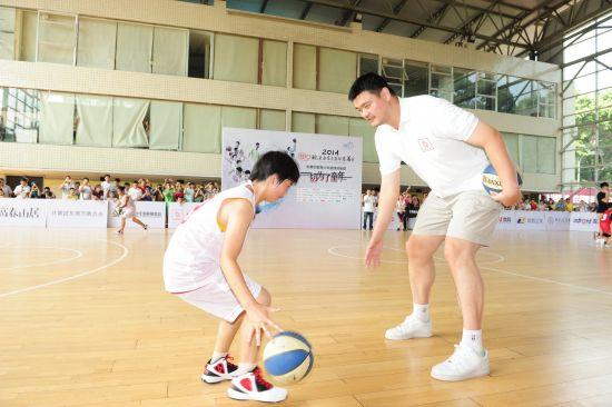 姚明与孩子们一起打篮球的温馨画面