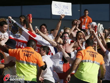 球迷手持标语牌在球场外合影