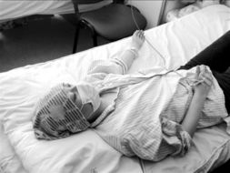 女孩躺在病床上接受治疗