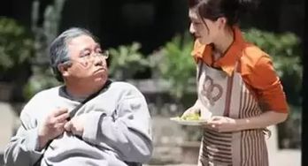 一位老年女性在灯光下认真绘制京剧脸谱