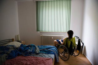 女子坐在轮椅上微笑看着窗外