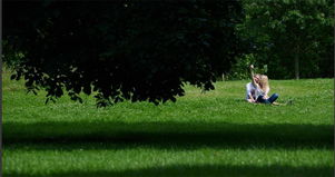 夫妻两人在公园草地上一起看书的场景