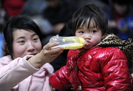 母亲在南昌火车站背孩子艰难前行