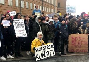 格蕾塔在抗议现场高举标语牌