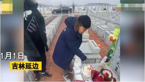 男孩在母亲墓前低头跪拜