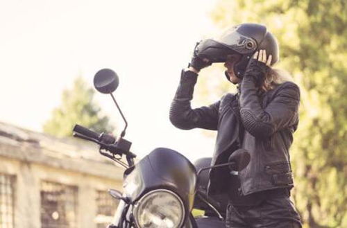 摩托车手佩戴头盔和护具骑行