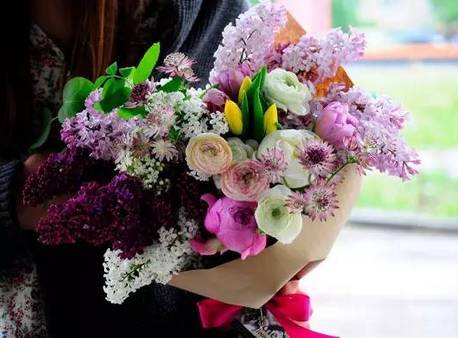 母亲怀抱Labubu花束在校门口等待