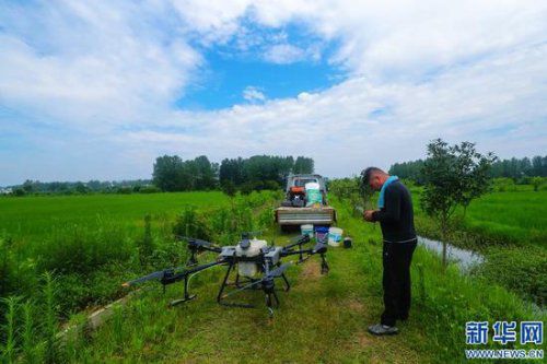 技术人员在田间指导农民使用科技产品