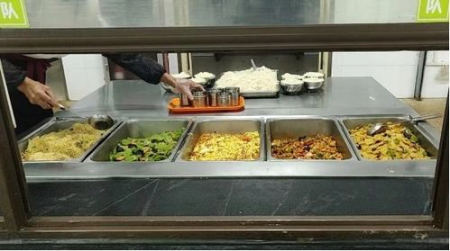 大学食堂夜晚灯火通明学生排队吃饭的场景