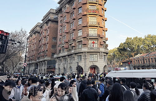 一群韩国游客在上海武康大楼前合影留念