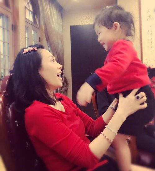 醒醒穿着红色连衣裙站在母亲身边的照片