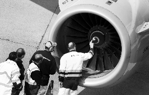 机场地勤人员检查飞机引擎