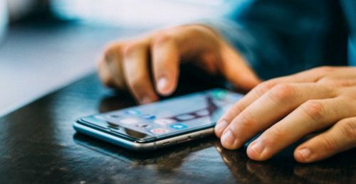 一个人在手机上打开国家反诈中心应用界面