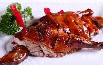 一位摊主正在将烤鸭装袋