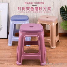 年轻人坐在塑料凳上吃面