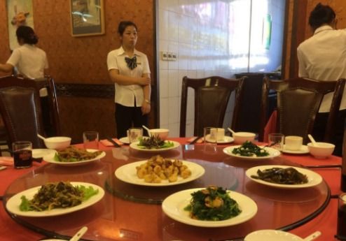 餐厅服务员为不同顾客端菜场景图