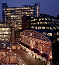 一个人站在城市高楼之间仰望天空