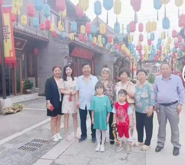 一家人站在田边合影微笑