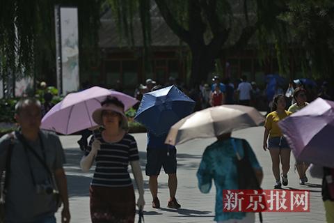 北京街头市民打伞遮阳
