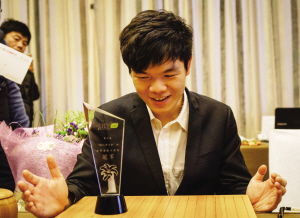 柯洁手捧着冠军奖杯笑容灿烂