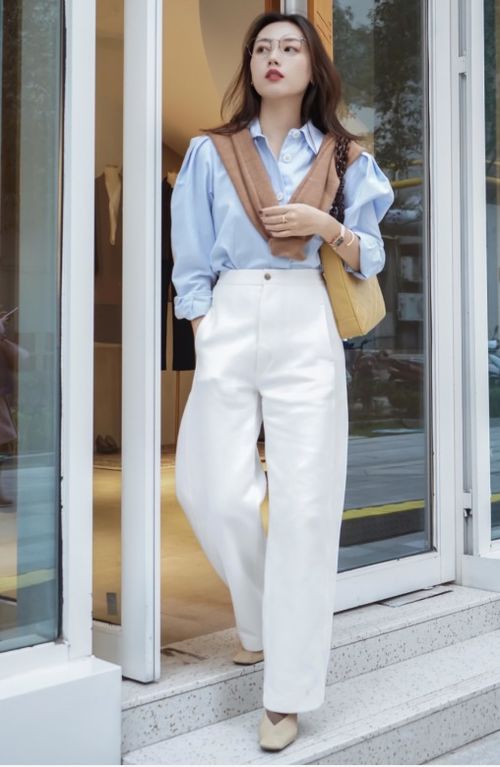 女生穿浅色七分裤搭配荷叶边上衣和草帽