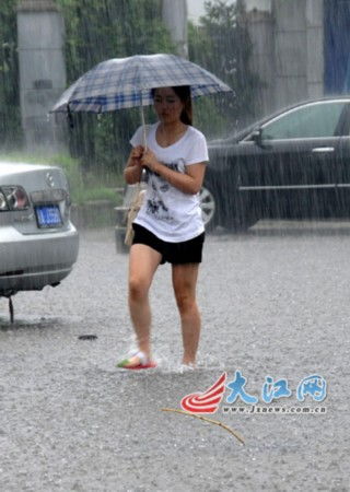 人们在暴雨中撑伞前行