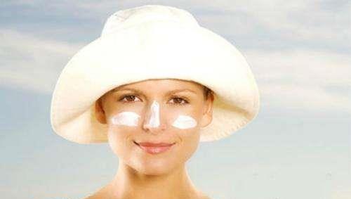 戴着帽子涂防晒霜的人