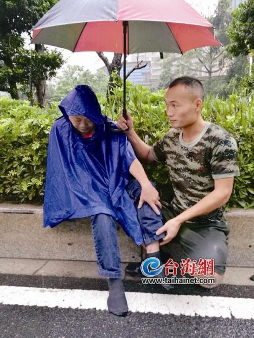 老人带着小孩走在雨中撑伞