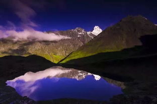巍峨高山下的一汪碧绿湖泊,湖水倒映着蓝天白云
