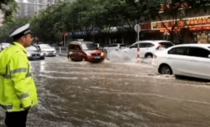 工作人员在雨中疏导交通