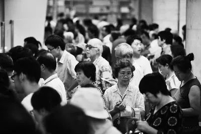 老人在人群里微笑挥手示意