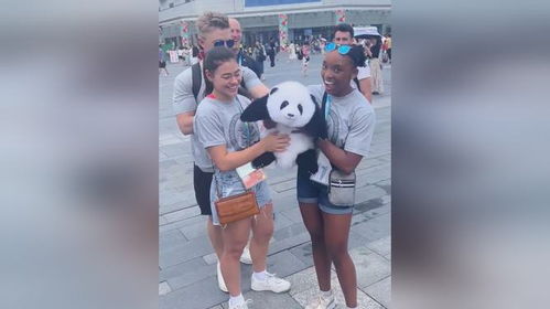 外国运动员抱着熊猫玩偶满心欢喜