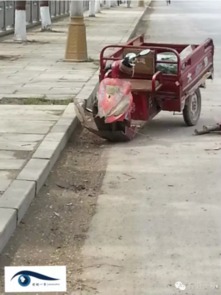 三轮车停在被撞坏的围墙边