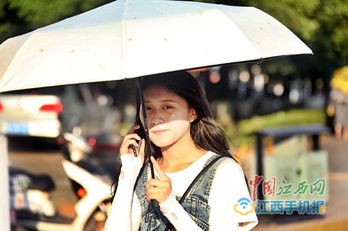 人们打着遮阳伞出行