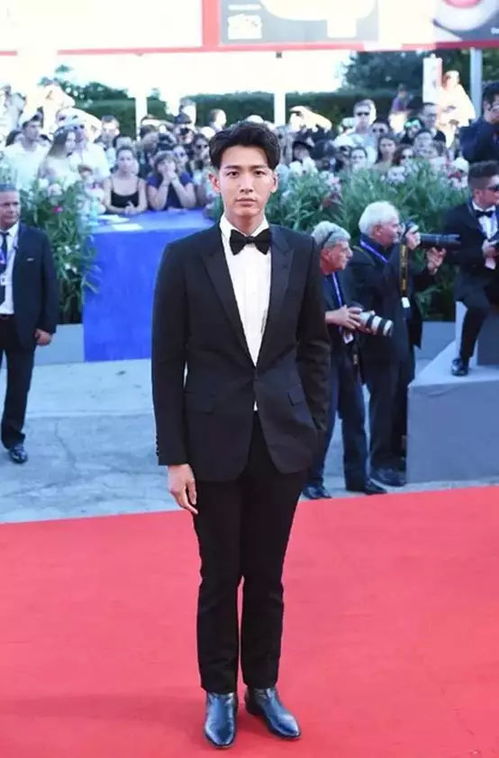 穿简约西装的男明星在红毯上微笑前行