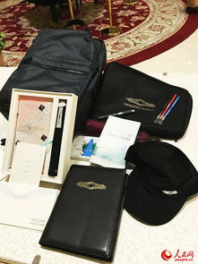这是媒体包内部的照片，可以看到里面的笔记本、笔、徽章和资料手册等物品整齐摆放