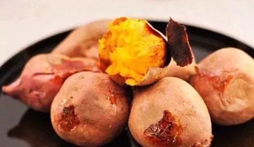 一个冒着热气的烤红薯被放在盘子里